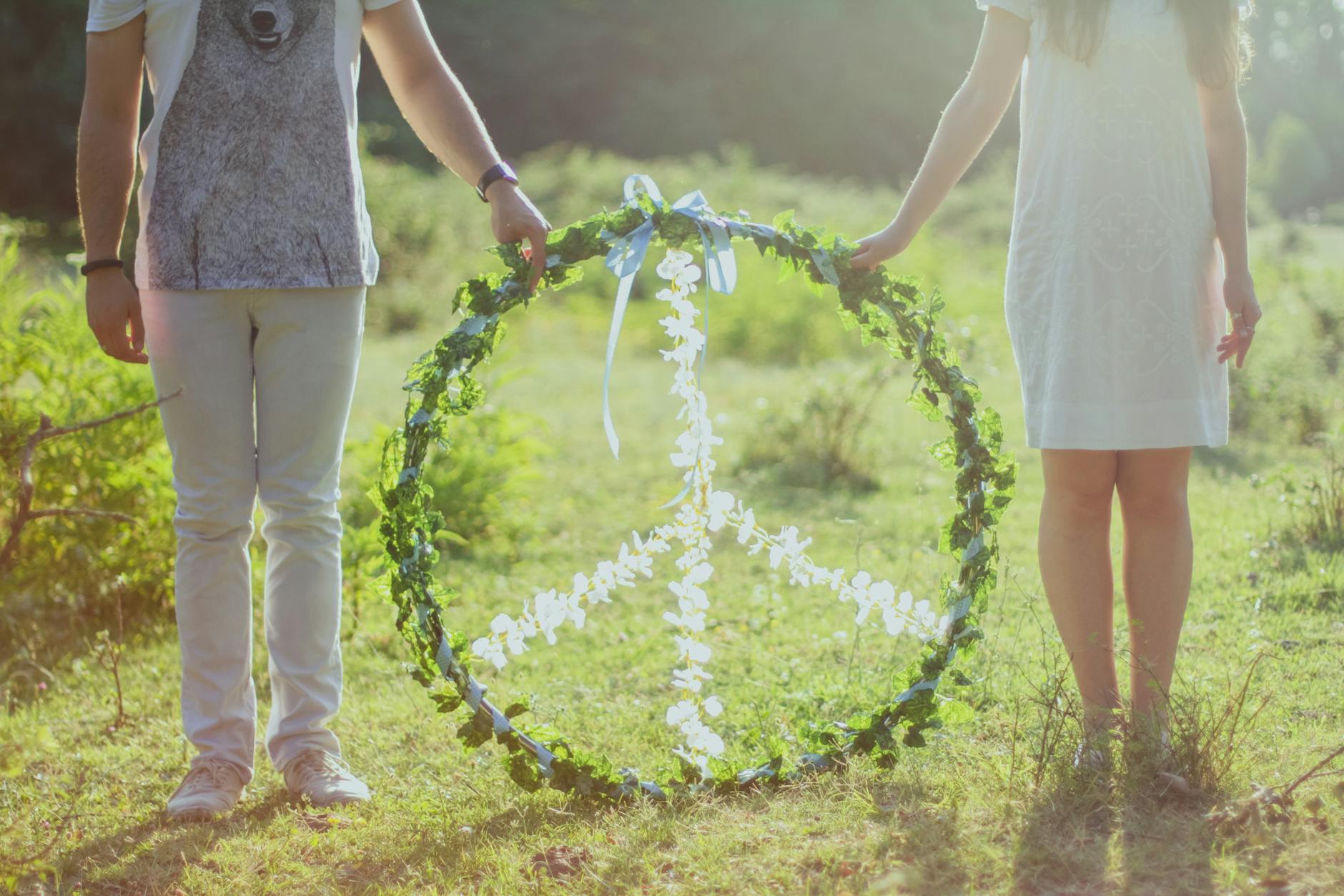 two person holding white and green peace wreath