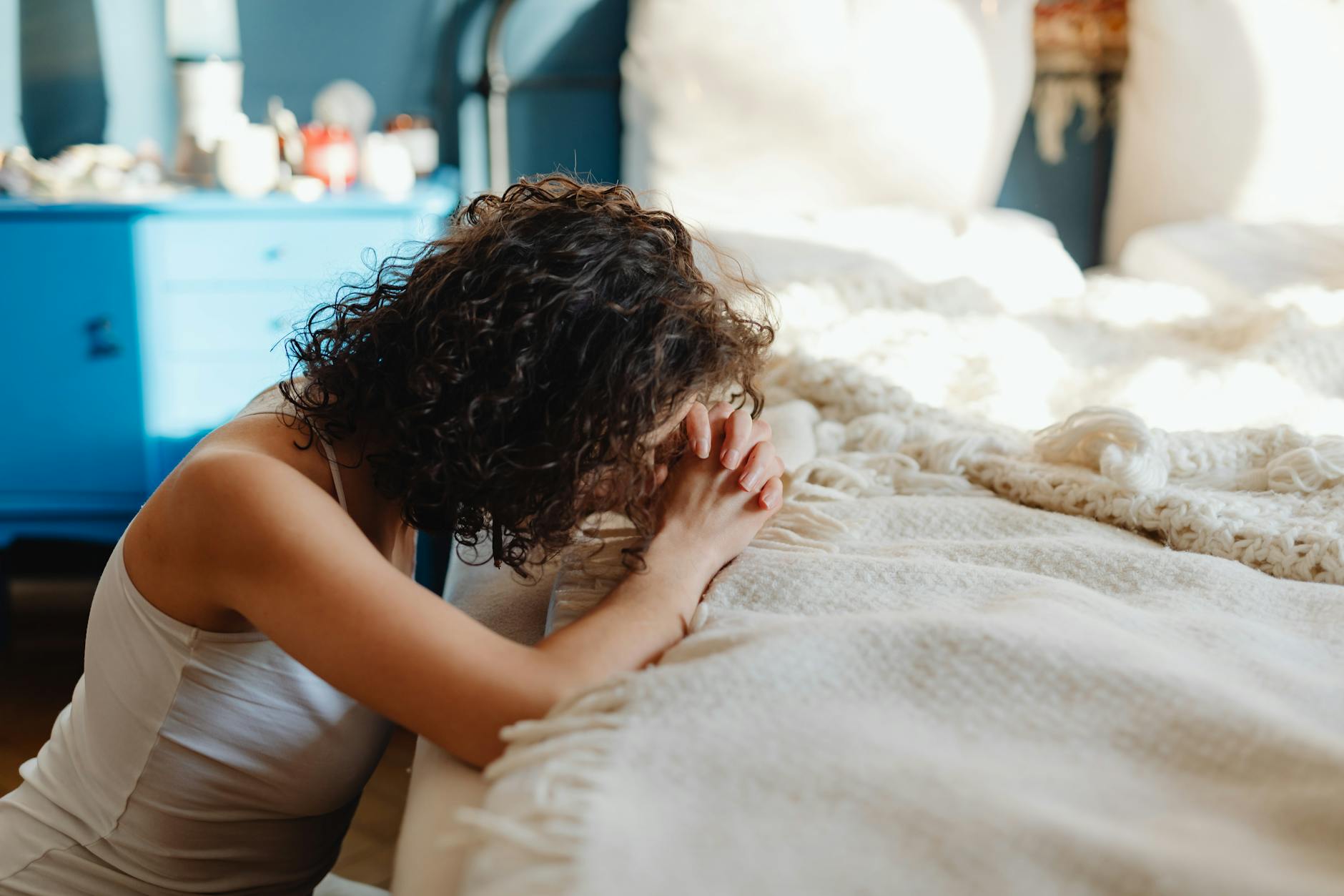 woman meditating by bed