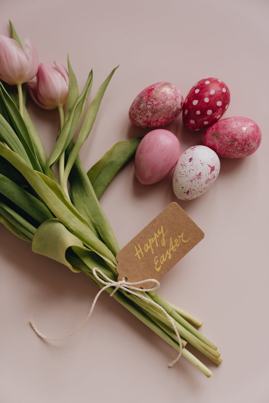 colorful easter eggs beside the blooming tulips